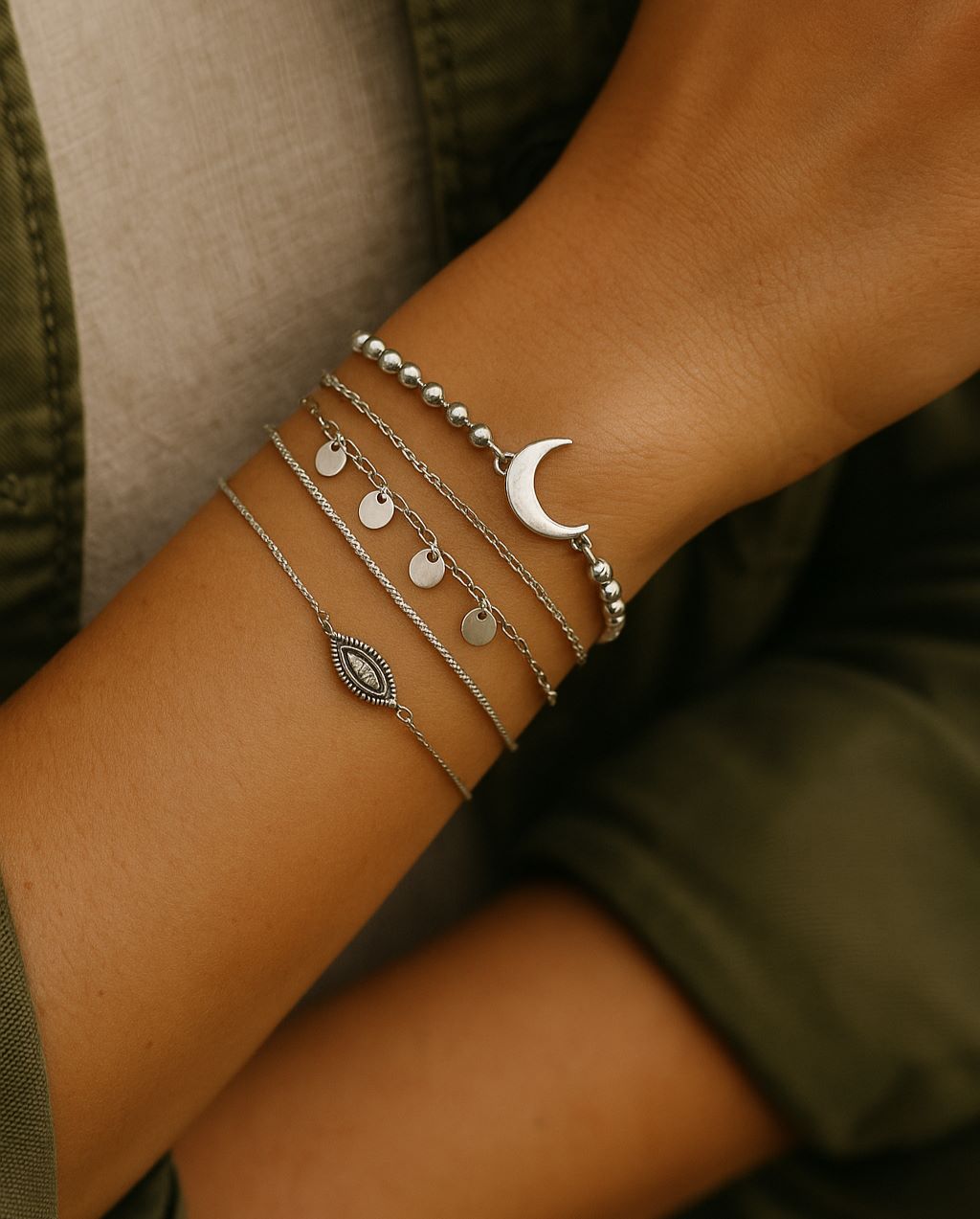 Poignet féminin orné de plusieurs bracelets multirangs argentés et bohèmes